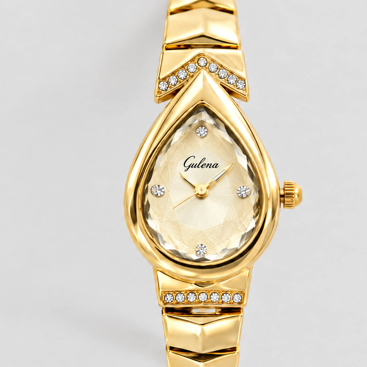 Close-up of the faceted teardrop dial and crystal-set chevron plates on the gold ISLA Teardrop Bracelet Watch