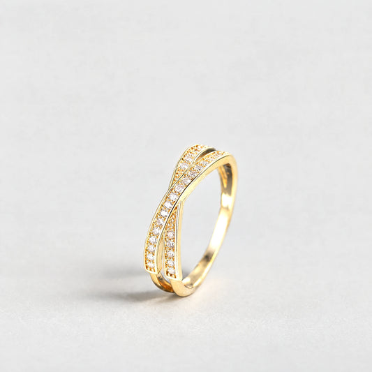 Gold Ivy Crossover Crystal Ring with clear crystals on a light grey background