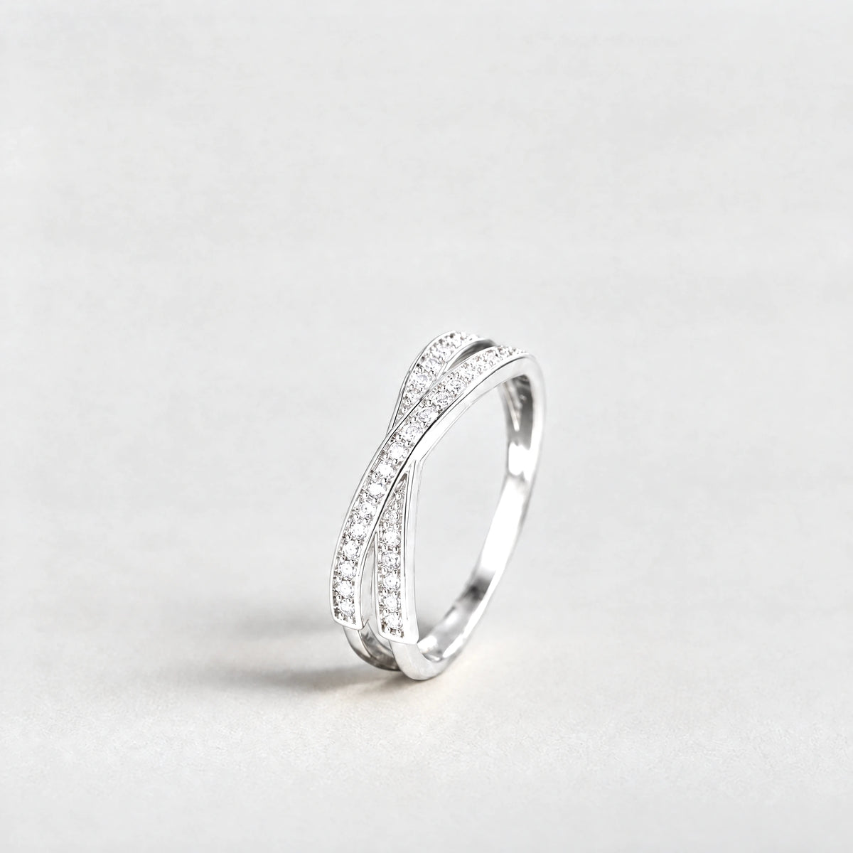 Silver Ivy Crossover Crystal Ring with clear crystals on a light grey background