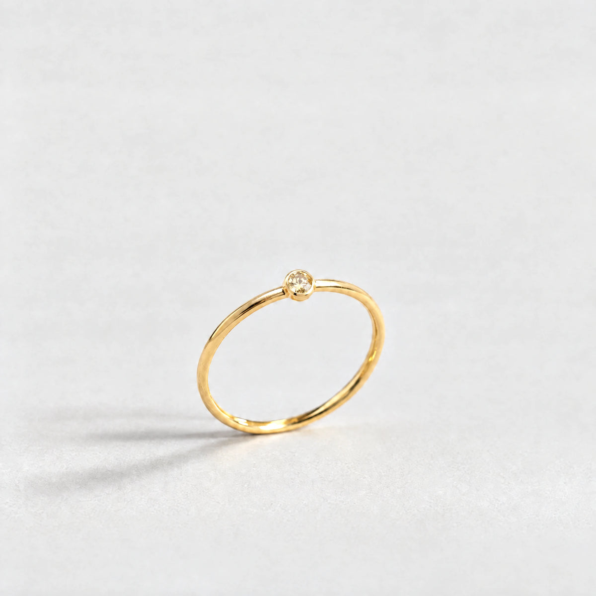 Gold Lena Birthstone Ring with citrine champagne November birthstone-color crystal on a light grey background