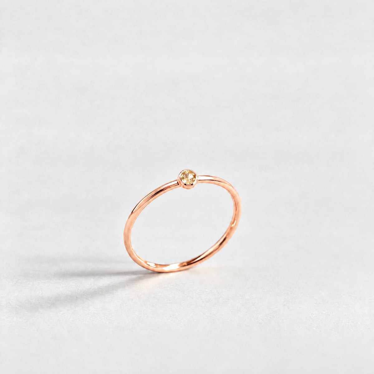 Rose gold Lena Birthstone Ring with citrine champagne November birthstone-color crystal on a light grey background