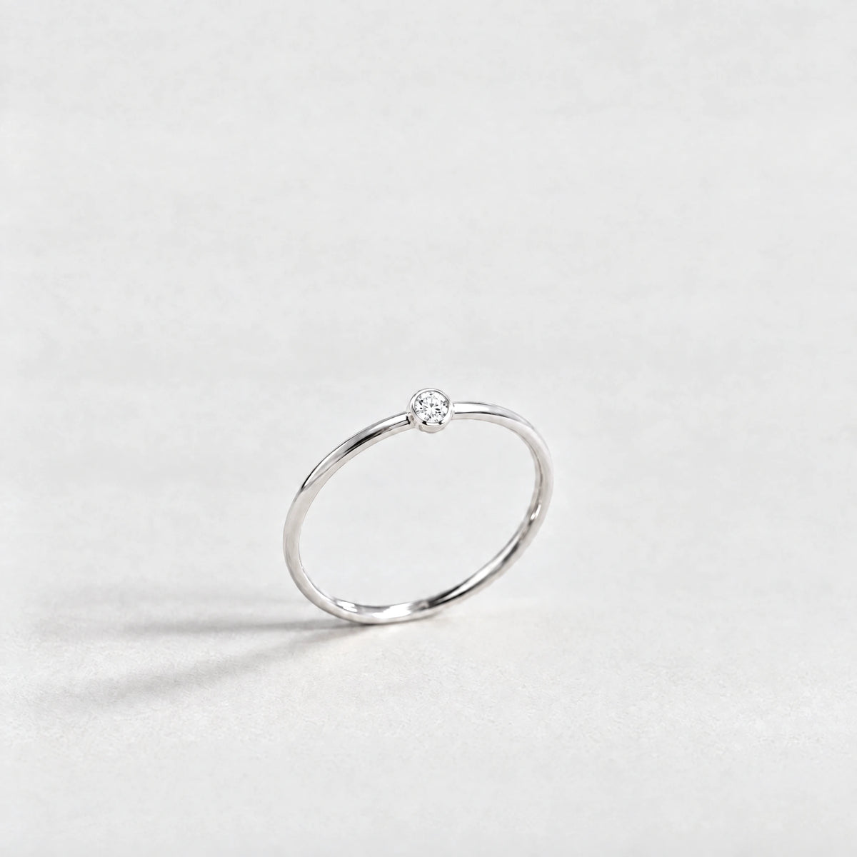 Silver Lena Birthstone Ring with crystal clear April birthstone-color crystal on a light grey background