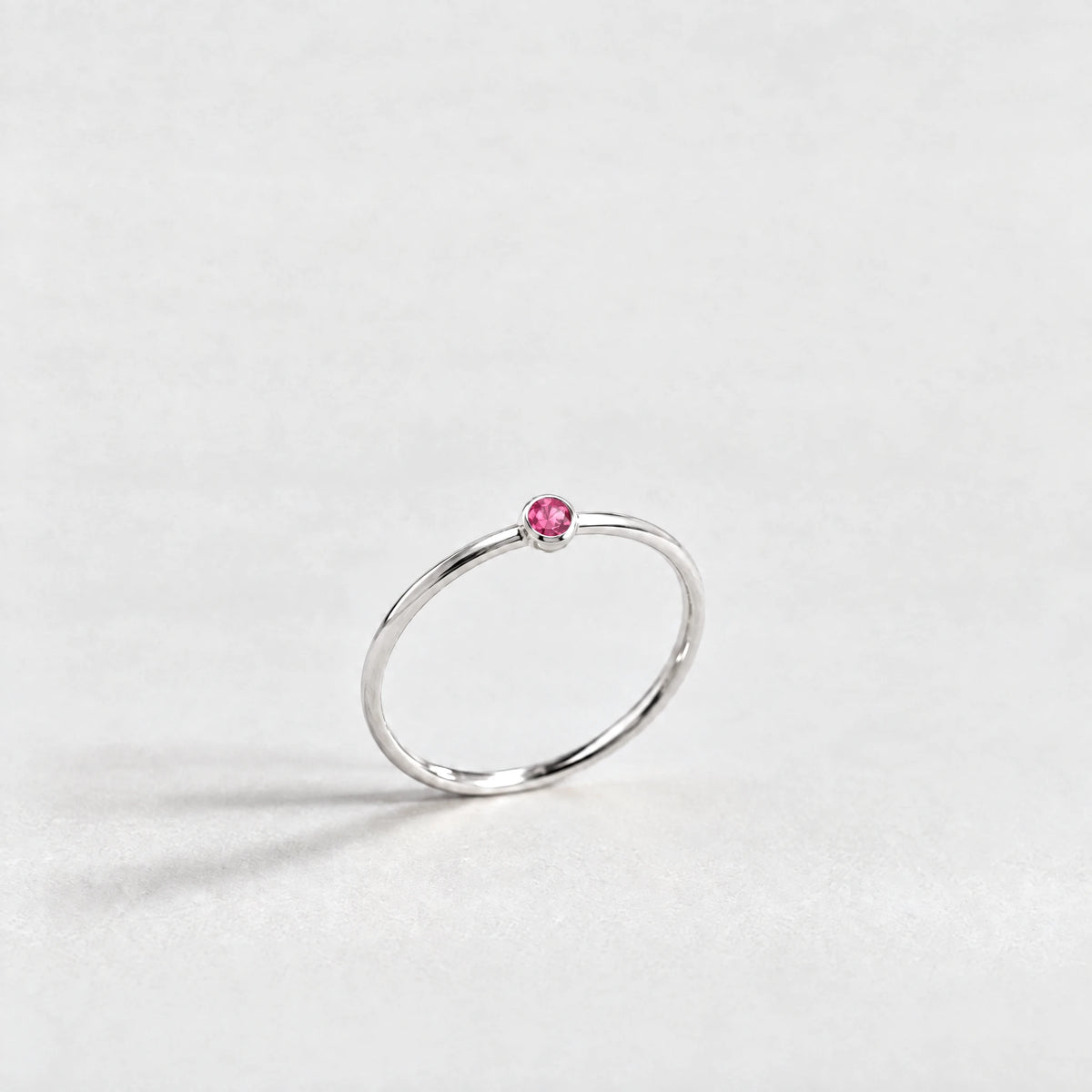 Silver Lena Birthstone Ring with ruby rose July birthstone-color crystal on a light grey background