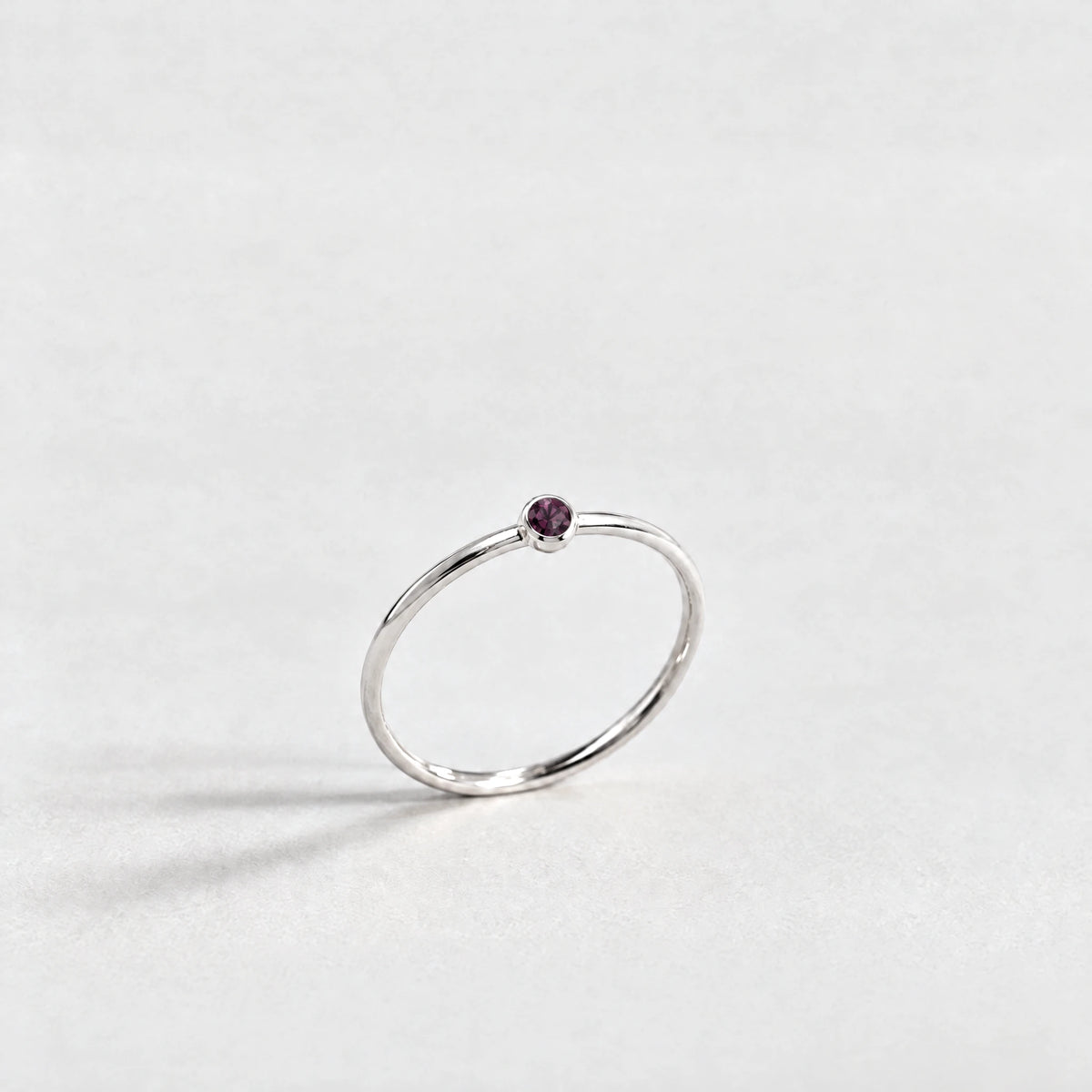 Silver Lena Birthstone Ring with alexandrite plum June birthstone-color crystal on a light grey background