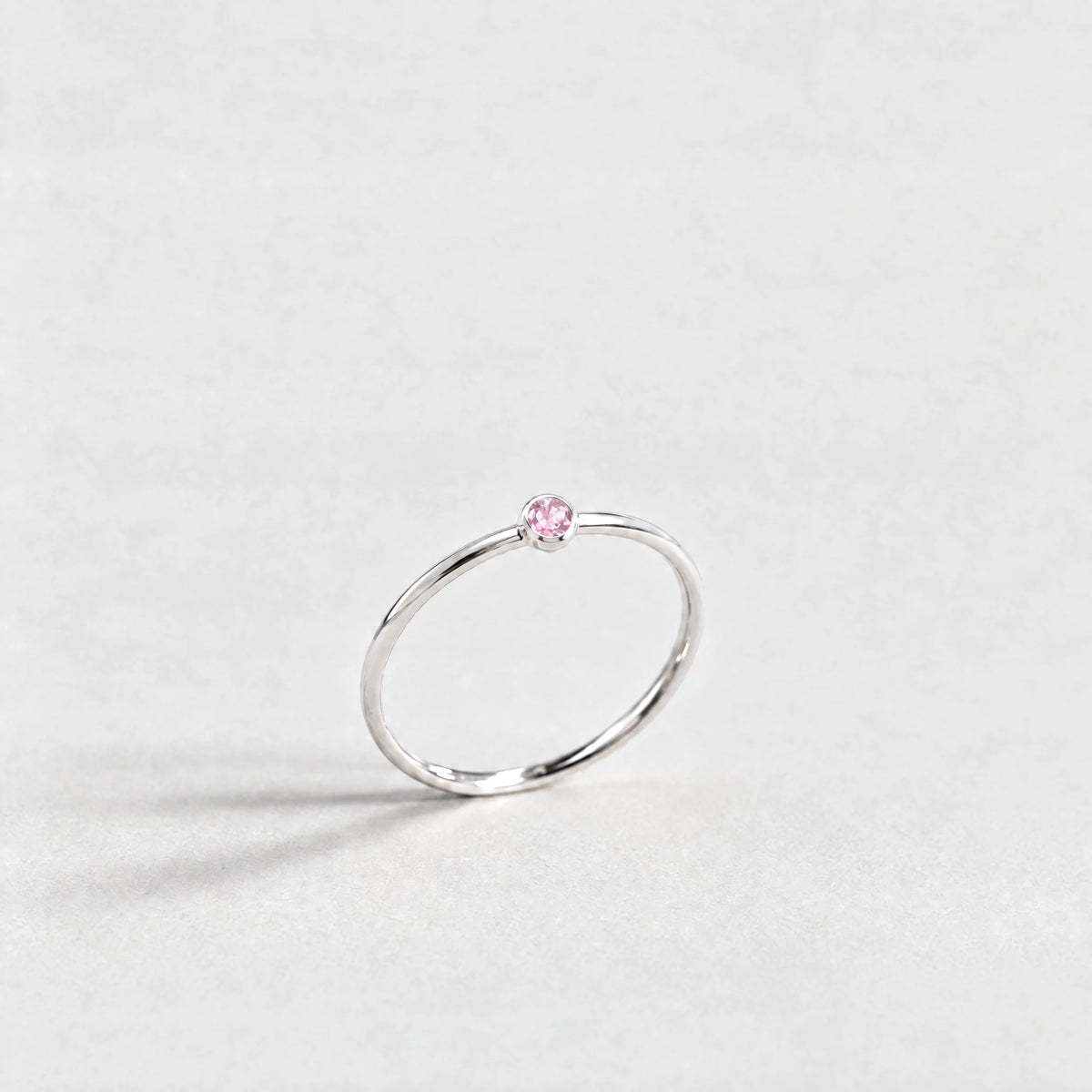 Silver Lena Birthstone Ring with tourmaline pink October birthstone-color crystal on a light grey background