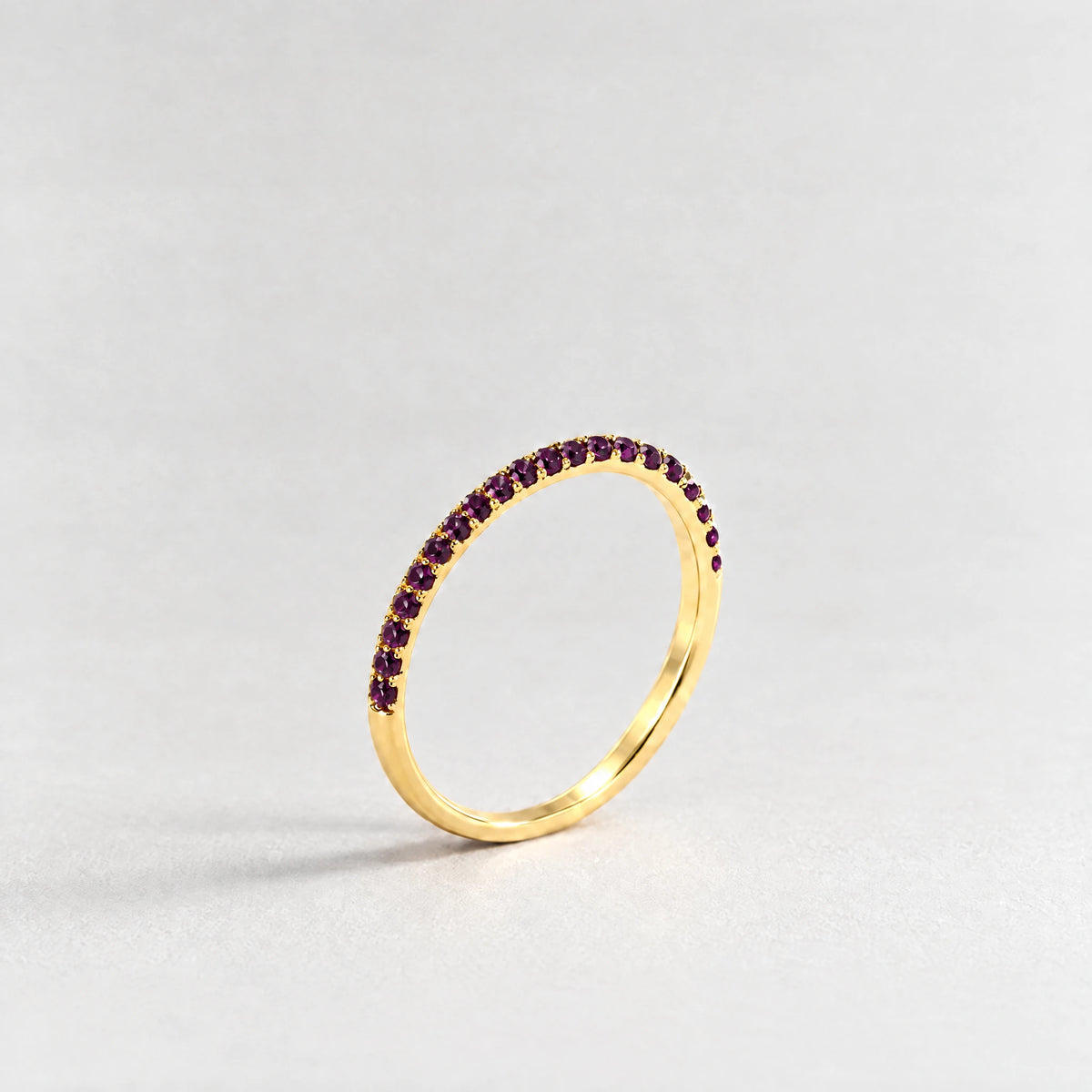 Gold Nora Birthstone Stacking Ring with alexandrite plum June birthstone-color crystals on a light grey background