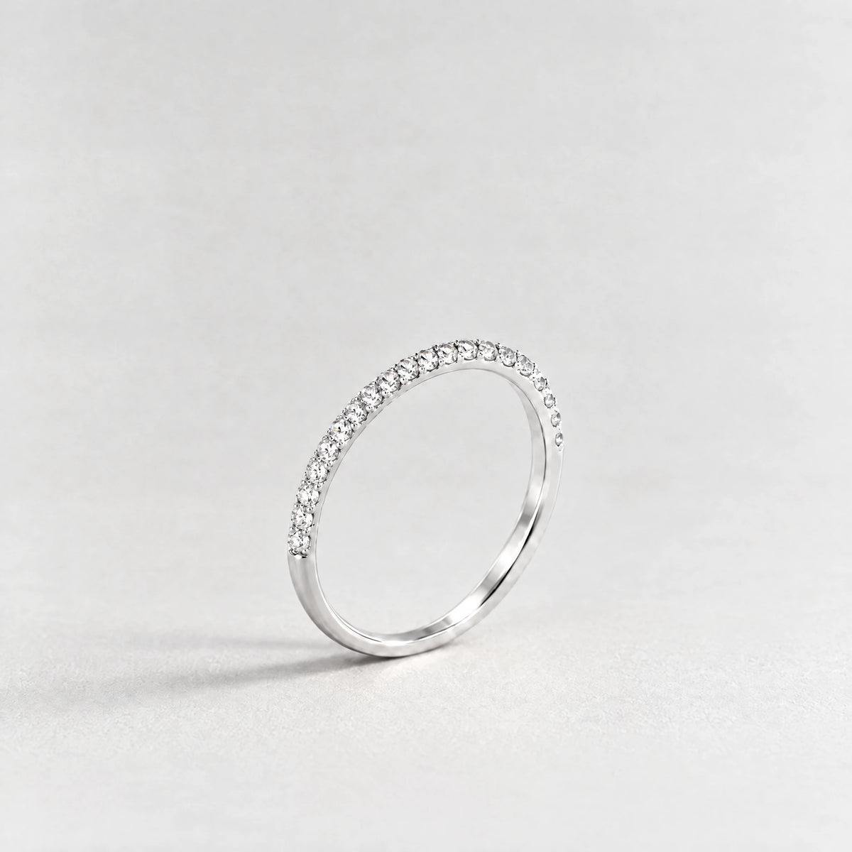 Silver Nora Birthstone Stacking Ring with clear crystal April birthstone-color crystals on a light grey background