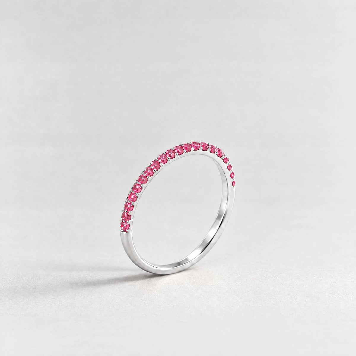 Silver Nora Birthstone Stacking Ring with ruby rose July birthstone-color crystals on a light grey background