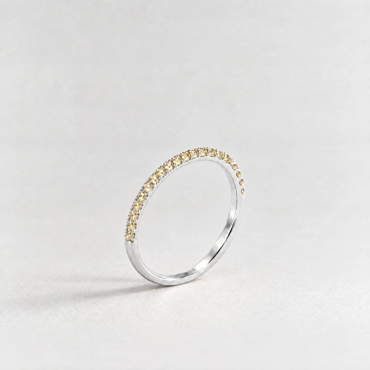 Silver Nora Birthstone Stacking Ring with citrine champagne November birthstone-color crystals on a light grey background