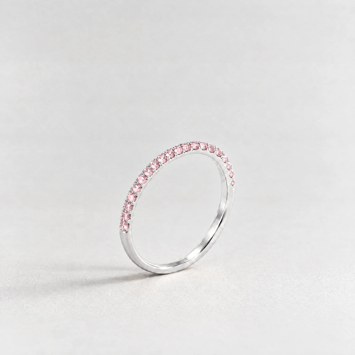 Silver Nora Birthstone Stacking Ring with tourmaline pink October birthstone-color crystals on a light grey background