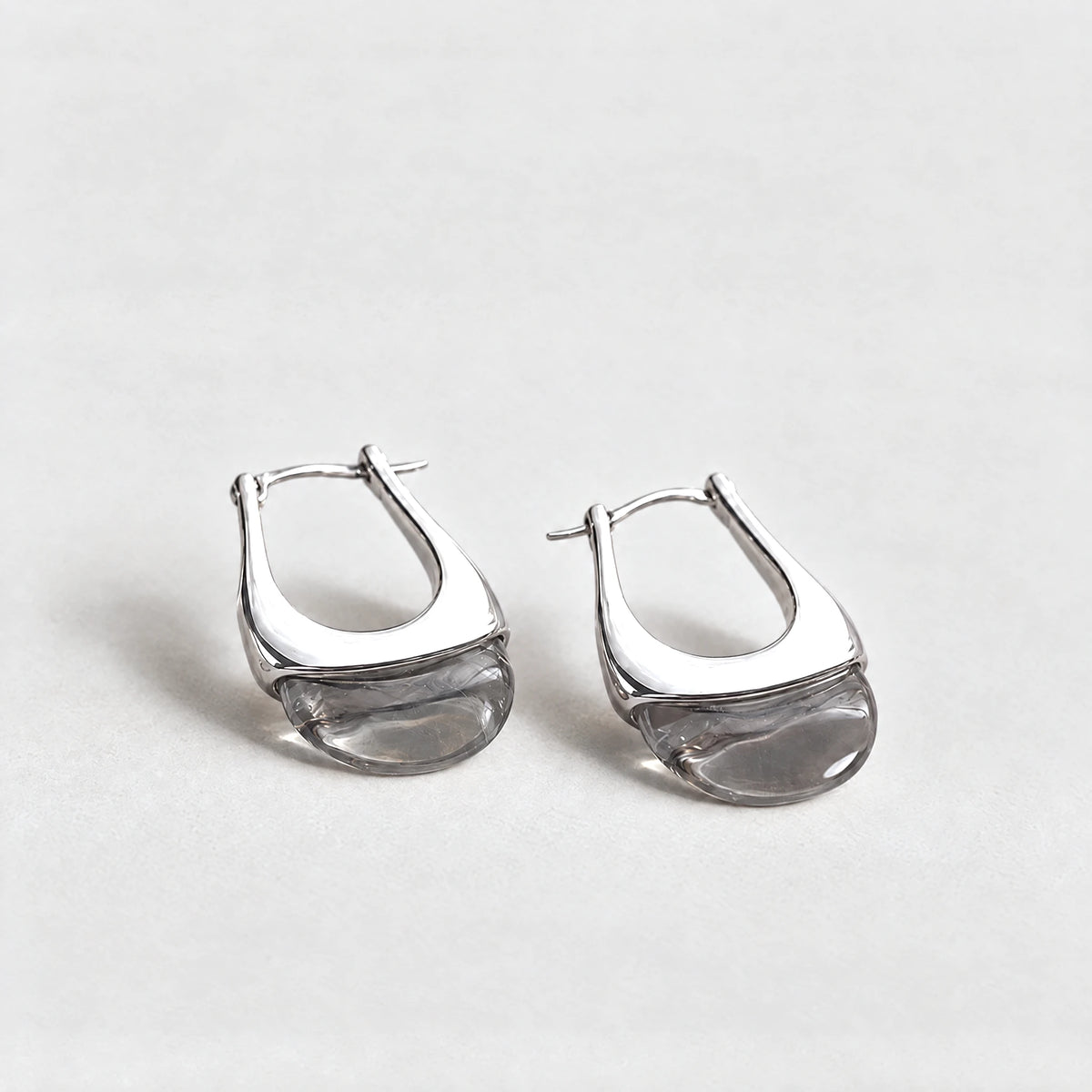 Silver Pia U-Shape Hoop Earrings with a smoke grey inset on a light grey background