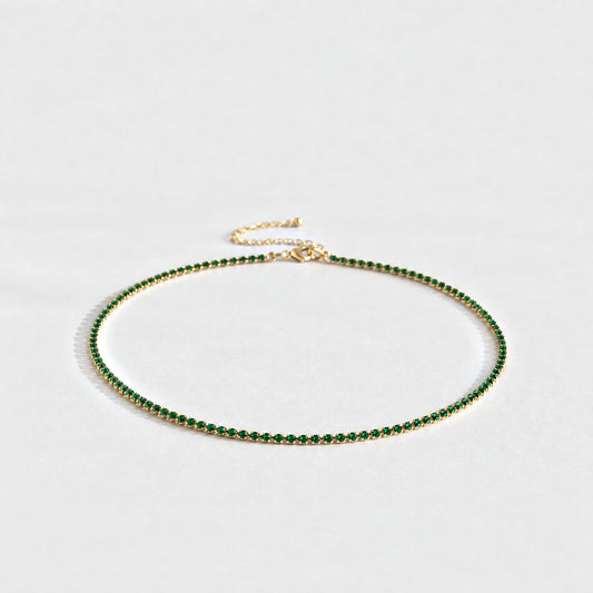 Gold Tessa Birthstone Tennis Necklace with emerald green May birthstone-color crystals on a light grey background
