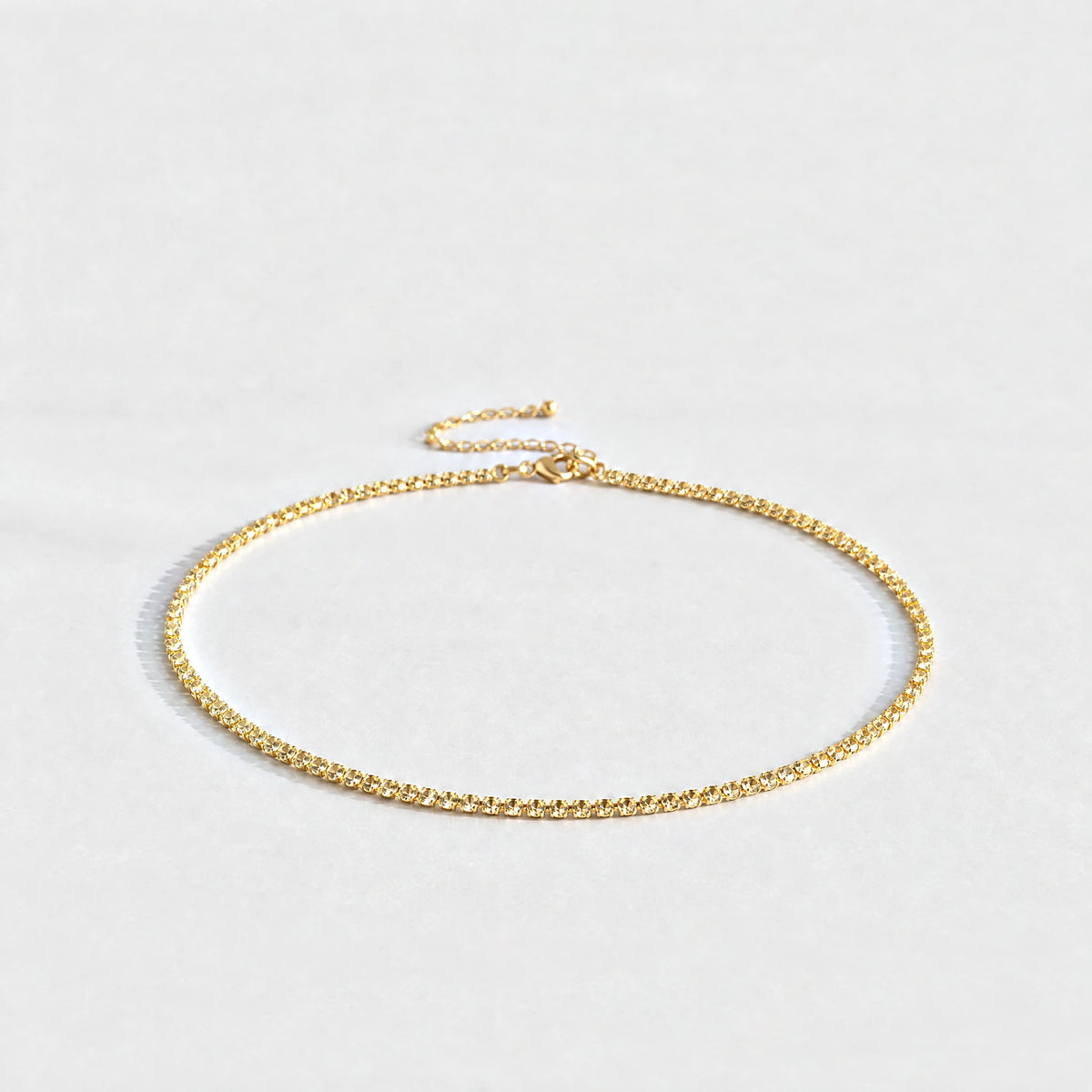 Gold Tessa Birthstone Tennis Necklace with citrine champagne November birthstone-color crystals on a light grey background