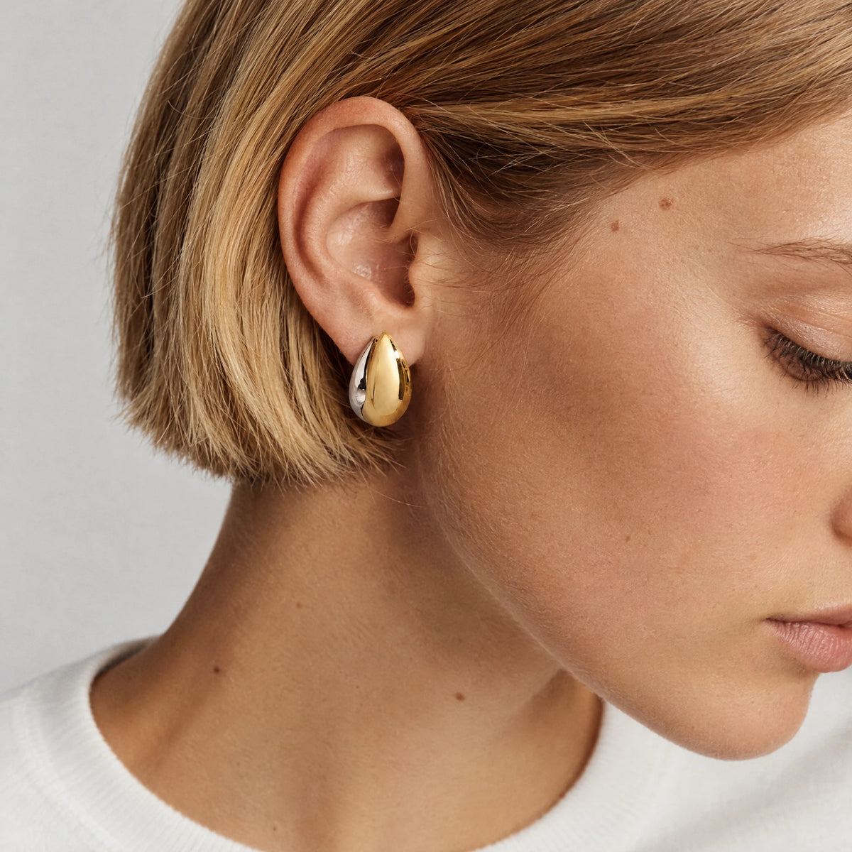 Blonde woman wearing a Vera Two-Tone Oval Hoop Earring