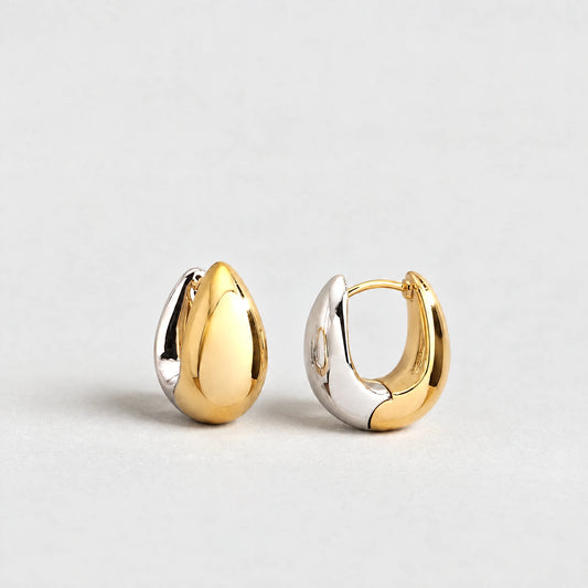 Vera Two-Tone Oval Hoop Earrings in gold and silver tones on a light grey background