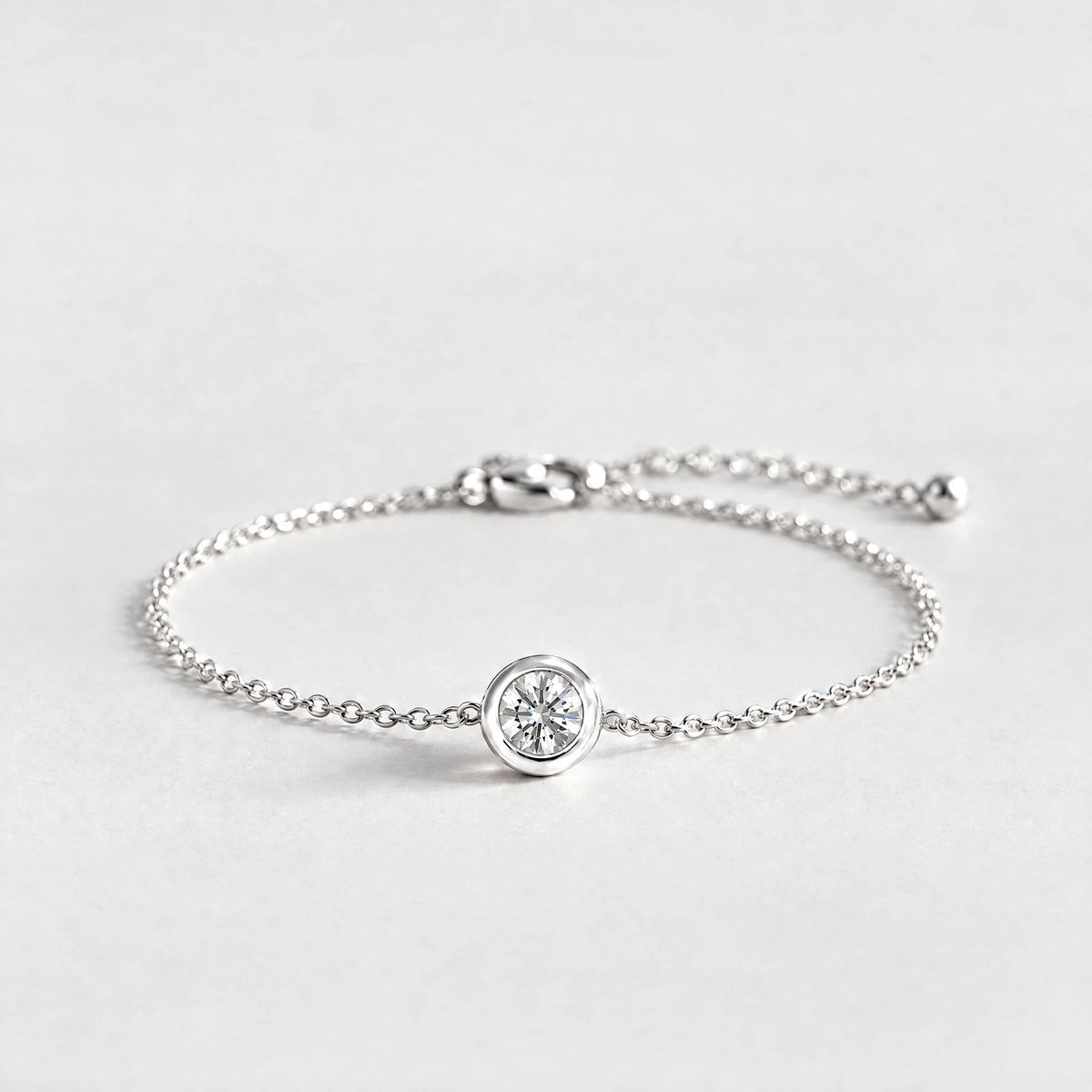 Silver Zara Birthstone Charm Bracelet with crystal clear April birthstone-color crystal on a light grey background