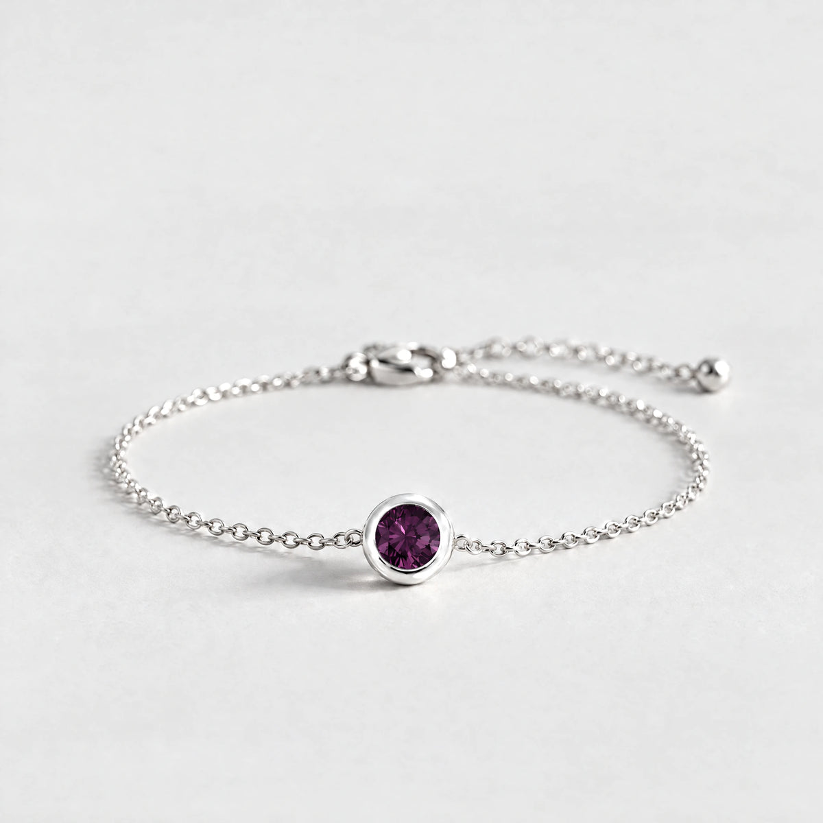 Silver Zara Birthstone Charm Bracelet with alexandrite plum June birthstone-color crystal on a light grey background
